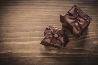 Packed glittery gift containers with ribbons on vintage wooden board