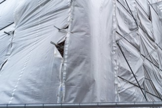 Building covered with a tarpaulin