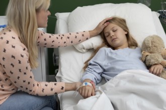 A mother comforts her sick daughter in a hospital bed, showing deep love and support during this