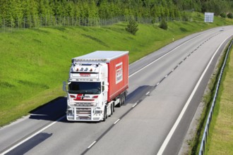 White and red Scania R560 semi trailer truck Toten Transport Oy transports goods along motorway