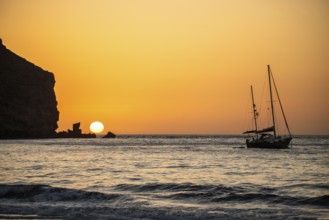 Sunrise during a storm, Calima. A haze-covered horizon turns orange as the sun rises as a ball. A