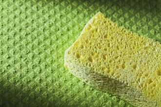 Yellow kitchen sponge on dishcloth
