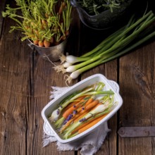 Young carrots and spring onions prepared for baking