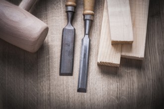 Wooden bricks mallet carpenter??™s flat chisels on wood background construction concept