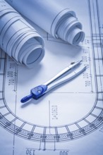 Blueprint rolls and pair of compasses construction concept