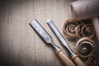 Planing chips wooden mallet carpenter??™s flat chisels on wood surface construction concept