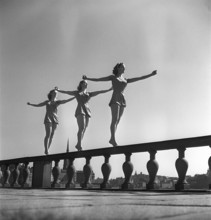 Gymnastics in the 1950s. Three young female gymnasts are standing on the wall outside Stockholm