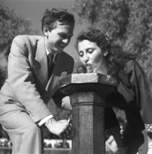 Summer in the 1940s. A girl drinks from a water fountain in one of Stockholms parks. These public