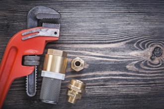 Pipe wrench check valve with strainer filter hose nipples on wooden board