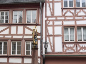 Half-timbered wall with statue of the Virgin Mary standing next to a street lamp post, mainz,