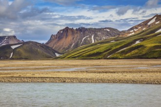 The magic of summer in Iceland. Cold water streams among yellow tundra. Landmannalaugar National