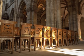An image of a row of wooden chairs in an old church
