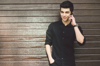 Portrait model young handsome male suspect Turkish middle eastern brunette in black shirt uses hand