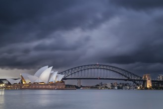 SYDNEY, AUSTRALIA, DECEMBER 03 2023: Sydney Opera House and Harbour Bridge at dusk during a summer