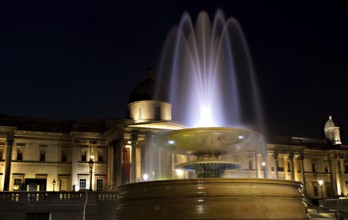 Illuminated Trafalgar Square with fountain and National Gallery, London, England London, England