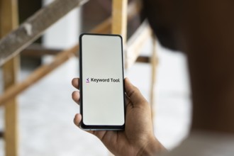 keyword tool logo is displayed on smartphone. Keyword Tool is a free online keyword research tool