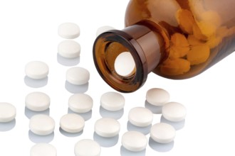 Many tablets with a glass container. Symbolic photo for addiction and costs in medicine and