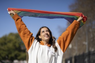 Lesbian girl waving LGBT flag with happy expression