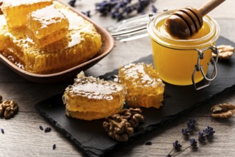 Honeycomb on slate tray with honey and nuts on kitchen table