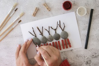 Diy Merry Christmas deer on greeting card postcard made of pebbles, sea stones, clothespins and