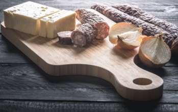 Tasty meal with homemade smoked sausages from beef and pork, fresh cheese and onion, displayed on a
