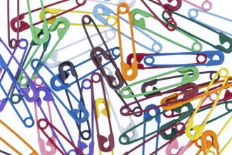 Many colourful safety pins lie on a white background Austria