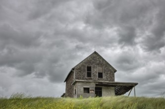 Abandoned Farm with storm clouds in the Canadian Prairie