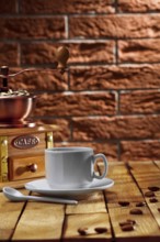 Coffee grinder and cup on table