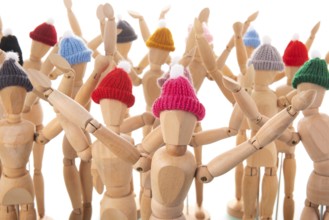 Many wooden mannequins with winter hat isolated over white