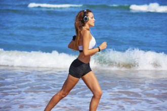 Beautiful brunette girl running in the beach at summer vacations