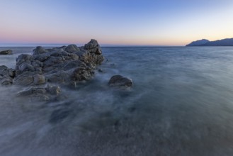 Rocks in the sea on the beach of Torre di Bari at sunset, long exposure, Torre di Bari, Bari Sardo,
