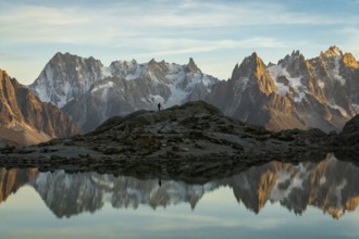 Silhouette of Hiker, Mountains and Reflection in Lac Blanc Lake at Sunset. Golden Hour. French