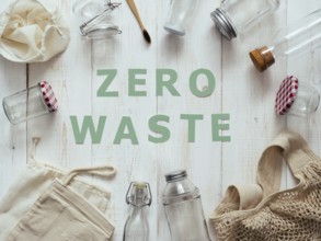 Zero waste concept. Textile eco bags, glass jars and bamboo toothbrush on white wooden background