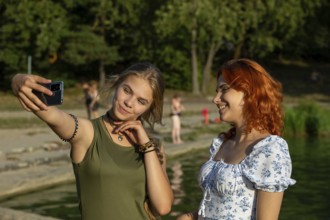 Two close friends are enjoying a bright and sunny day while capturing wonderful memories with a fun