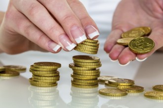 A woman stacks coins. Saving money for the future. Austria