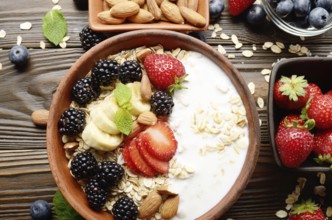 Flat lay top view at Fruit healthy muesli with banana strawberry almonds and blackberry with yogurt