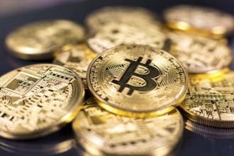 Stack of bitcoins lying on shiny dark surface