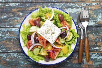 Traditional Greek Salad with Feta Cheese, Tomatoes, Bell Pepper, Cucumbers, Olives, Herbs in white