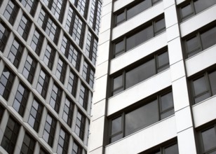 Close up detail of tall high rose modern apartment buildings with white cladding and dark windows