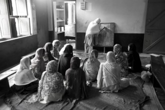 Muslim teacher with children in classroom Islamic school uttar pradesh India Asia