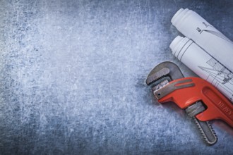 Monkey wrench construction plans on metallic background plumbing concept