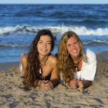 Girls friends having fun happy lying on the beach sand shore