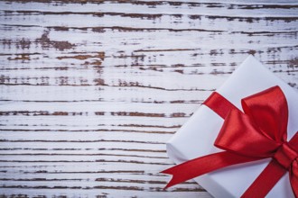 Present box red tape on vintage wooden board greeting card