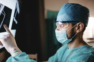 Surgeon pointing at detailed x-ray results for evaluation
