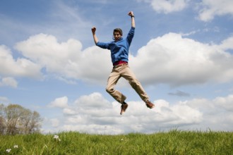 Happy jumping man outdoor in the fields