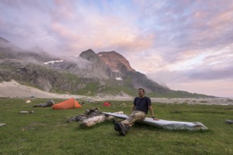 Man resting by the tent, Buneset, Moskenesöya, Lofoten, Nordland, Norway, July 2015, Europe