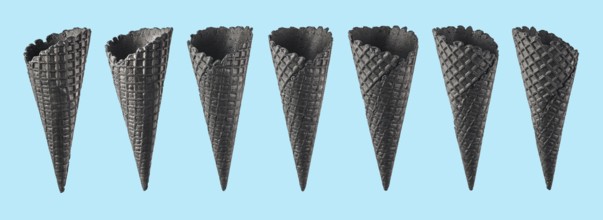 Various ice cream cones isolated on blue background. Various perspective of black waffle sugar