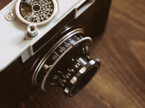 Close up photo of old vintage camera lens over wooden table. selective focus
