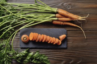 Top view at fresh organic Carrots on kitchen wooden table