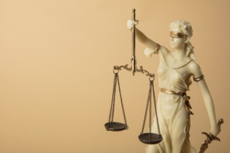 Justizia Figur auf beige Hintergrund